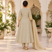 Golden cream embroidered A-line suit for women with pink bird and floral motifs, matching pants and embellished dupatta