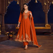 Rust orange royal embroidered Anarkali suit for women with flared kurta, matching wide-leg trousers and coordinating dupatta